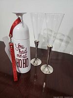 Travel bottle and two champagne flutes standing upright
