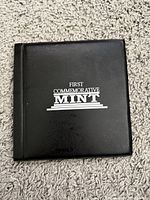 Front cover of black album showing First Commemorative Mint branding