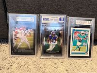 Front view of all three graded rookie cards in slabs