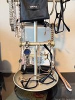 Full stand view showing all jewelry, watches, eyewear, Versace pouch