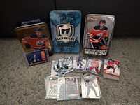 Overall lot showing three storage tins, stacks of sleeved cards, and a small card holder