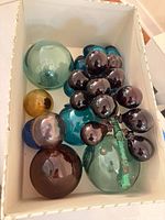 Box containing grape clusters and assorted floats