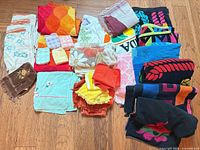 Group shot of entire lot laid out on wood floor showing variety of towels and colors