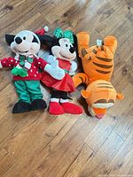 Full view of Mickey, Minnie and Tigger plush toys on floor