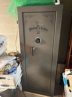 Full view of gray Liberty gun safe beside other items, showing size and single door