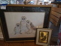 Large framed print of three owls alongside smaller framed print of two owls