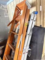 Wooden step ladder and Werner aluminum extension ladder leaning together