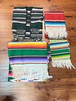 All four items laid out: vest, red blanket, large green blanket, small runner