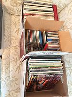 Two boxes filled with vinyl records and CDs