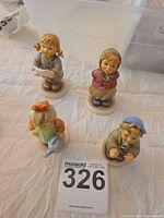 Group of four MI Hummel child figurines on tabletop