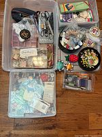 Overview of three large bins and two small containers with sewing items