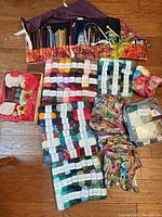 Overview of all yarn assortments, bag of floss and rolled case of needles