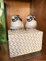 Two silver-tone owl shakers on Napier box