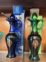 Front view of both glass decanters with stoppers and boxes