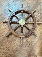 full view of 8-spoke wooden ship's wheel on floor
