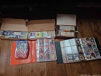 Three storage boxes of cards and two binders displayed on floor