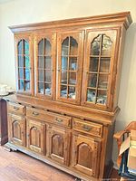 Full view of two-piece china cabinet showing hutch with glass doors and buffet base with drawers and cabinet doors