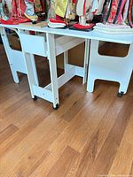 Table front view showing foldable leaf and casters