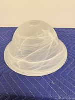 Side view of domed white opal frosted glass bowl shade showing swirled pattern