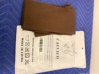 Folded brown tights with front of CACCICO package