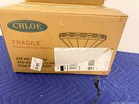 Factory box front with Chloe logo and lamp illustration