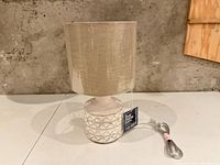 Overall view of lamp showing ceramic base, fabric shade and power cord