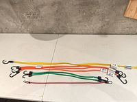 Six assorted color bungee cords laid flat showing full length, hooks visible