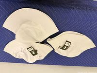 Top view of three white bucket hats showing brims