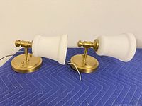 Pair of brass wall sconces with shades, side view showing finish and wiring