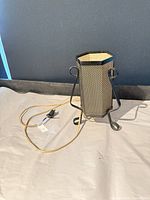 Full view of hexagonal black metal mesh table lamp with cord