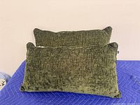 Two olive green lumbar pillows on surface