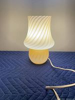 Lamp illuminated showing yellow base and ivory swirl shade