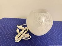 Full lamp with cord and inline switch on padded surface