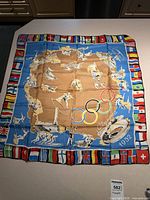 Full view of 30x30 silk scarf showing flag border and central Olympic graphics