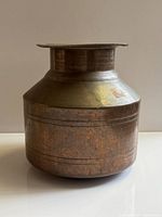 Side view of antique brass spittoon showing shape, patina, and size