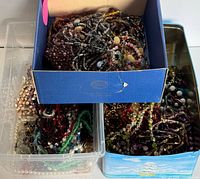 Bulk lot in bins and box showing numerous glass bead necklaces and pendants