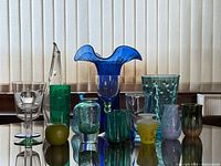 Entire group of thirteen blue and green art glass pieces displayed together