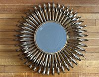 Front view of circular mirror with metal sunburst frame