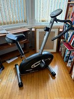 Full view of Proteus compact exercise bike showing frame, seat, handlebars, and console
