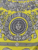 Close-up of Medusa roundel and floral Barocco pattern on yellow silk