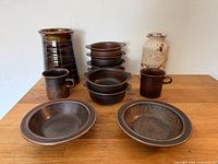 Complete lot showing two vases, two mugs, four handled bowls, two shallow bowls