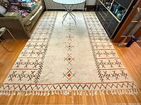 Full view of rug on floor showing overall design, size and fringe