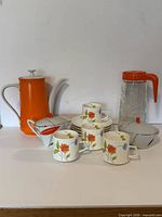 Group view of coffee pot, Tang pitcher, four cups, four saucers and two serving pieces