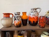 Front view of all five West German pottery vases on shelf