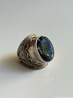 Front angled view showing glass stone color play and bezel setting