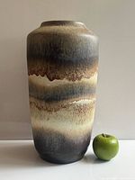 Full view of tall drip-glazed West German vase next to apple for scale