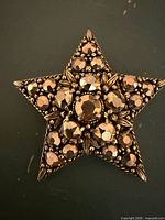 Front view of copper-tone rhinestone star brooch