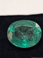 Close-up of oval lab-created emerald showing facets and color