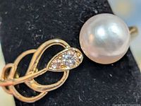 Close-up of pearl and leaf setting with accent stones