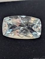 Top view of cushion-cut aquamarine showing facets and colour